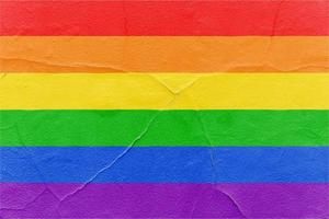 bandeira do arco-íris do orgulho pintada na parede texturizada rachada. fundo de textura grunge ao ar livre foto