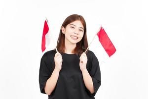 sorrindo e segurando a bandeira indonésia de linda mulher asiática isolada no fundo branco foto