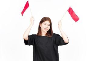 sorrindo e segurando a bandeira indonésia de linda mulher asiática isolada no fundo branco foto