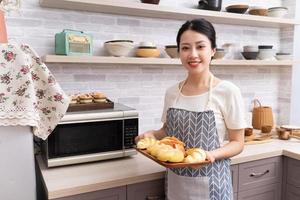 jovem mulher asiática se preparando para cozinhar na cozinha foto