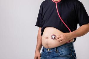 check-up médico conceito pessoas gordas segurando o estetoscópio médico vermelho para verificar sua saúde e corpo. tiro de estúdio em cinza foto