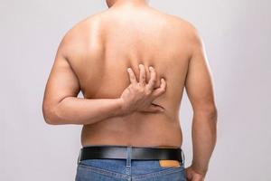 cuidados com o corpo ou retrato do conceito de coceira ou tinea cruris de pessoas usando as mãos para coçar as costas. tiro de estúdio em cinza foto