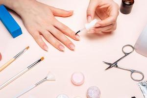 uma garota fazendo manicure em casa, close-up de mãos. A vista do topo foto