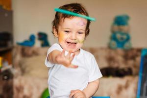 um menino brinca com marcadores coloridos em um pedaço de papel foto