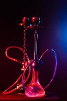 cachimbo de água moderno, shisha em um fundo preto com iluminação neon foto