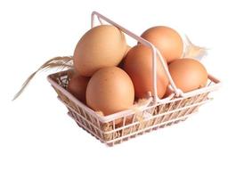 ovos de galinha crus em uma cesta em um fundo branco foto