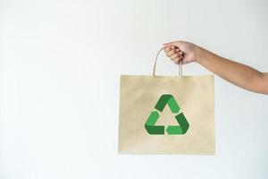 mulher carregando saco de papel conceito de reutilização, recicle o objeto para zerar o desperdício. conceito de sustentabilidade usando sacolas de papel reciclado para fazer compras. foto