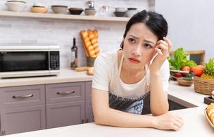 jovem mulher asiática se sentindo cansada do trabalho doméstico foto