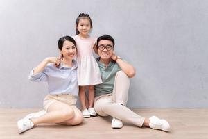 jovem família asiática sentada no chão foto