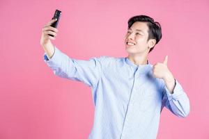 foto de jovem asiático usando smartphone em segundo plano