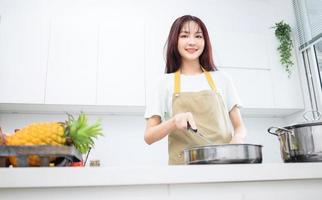 imagem de jovem asiática na cozinha foto