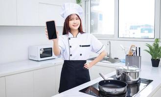 imagem do chef jovem mulher asiática na cozinha foto