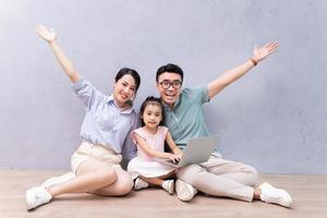 jovem família asiática sentada no chão foto