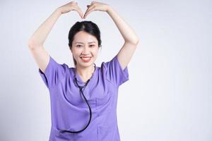 retrato de jovem enfermeira asiática em fundo branco foto
