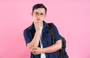 imagem de jovem estudante universitário asiático em fundo rosa foto