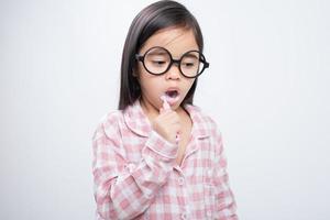 menina ásia escovando os dentes alegremente fundo branco foto