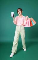imagem de jovem asiática segurando a sacola de compras no fundo foto