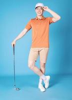 imagem do jogador de golfe jovem asiático no fundo azul foto