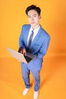 imagem do jovem empresário asiático usando laptop no fundo foto