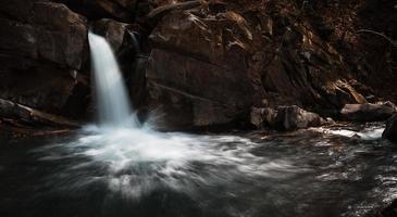 cachoeira com pedras e água corrente foto