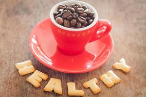 grãos de café em uma caneca com letras do alfabeto foto