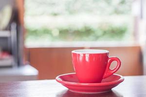 xícara de café vermelha em uma mesa foto