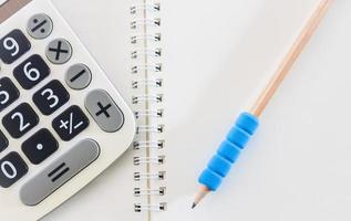 close-up de uma calculadora e lápis em um caderno foto