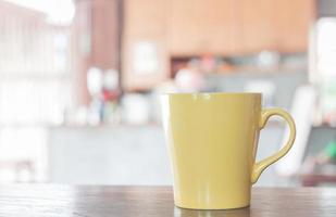 caneca de café amarela em um café foto