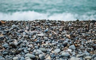 pedras cinzentas e pretas perto do mar durante o dia foto