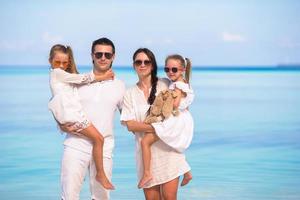família em roupas brancas em uma praia foto