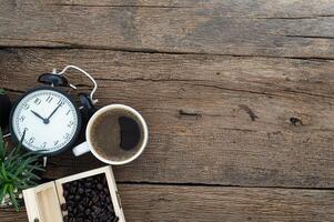 mesa de madeira com café e despertador foto