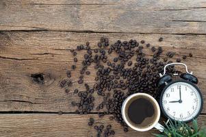 mesa de madeira com grãos de café e despertador foto