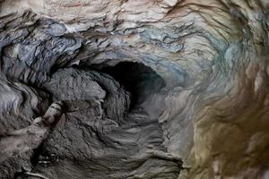 pequena gruta escura em formação rochosa em camadas. foco seletivo. foto