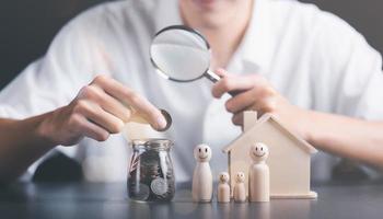 conceito financeiro e economia de dinheiro, economia de investimento, planejamento de economia para o futuro, fundo de aposentadoria, preparação financeira, gerenciamento de risco futuro, homem segurando dinheiro, moedas e lupa foto