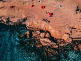 Ilha de Hengam, Irã, 2020 - pessoas perto de um penhasco na praia foto