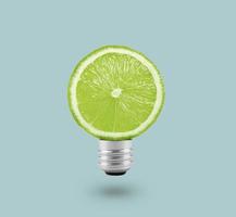 lâmpada de limão verde sobre fundo azul brilhante. conceito de diversão de verão foto