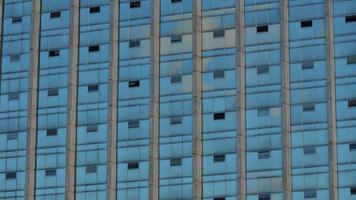 abordagem para as janelas de vidro refletindo um céu azul de um edifício moderno. fundo abstrato foto