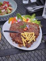 costelinha de porco grelhada com batatas fritas no prato foto