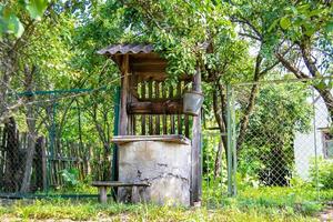 poço velho com balde de ferro na cadeia longa forjada para água potável foto