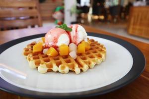 um prato de sorvete de waffle em uma mesa de café foto