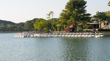 pato de barco giratório alinhando-se com pessoas girando pato de barco giratório no lago de armazenamento de água ou reservatório no parque público suan luang rama ix.
