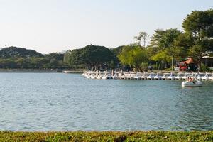pato de barco giratório alinhando-se com pessoas girando pato de barco giratório no lago de armazenamento de água no parque público suan luang rama ix. foto