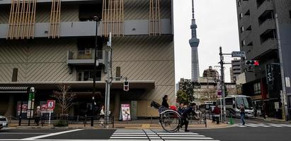 Tóquio, Japão, em julho de 2019. condições em uma rua em Tóquio, onde você pode ver a passagem de pedestres e turistas andando de riquixás turísticos foto