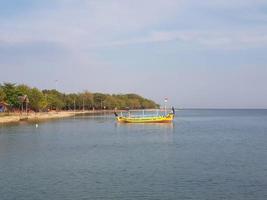 um píer para navios âncora e pequenos barcos em uma praia chamada praia de tirta samudera ou praia de bandengan foto