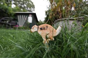 uma estatueta engraçada de um cachorro fazendo cocô na grama. foto