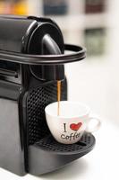 uma máquina de café derrama café em uma caneca com a inscrição eu amo café foto