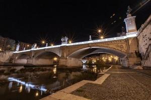 Roma, Itália, a ponte na cidade noturna está lindamente iluminada. foto