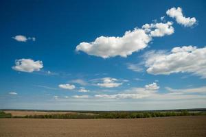 bela paisagem de céu azul com nuvens e campo na ucrânia foto