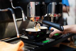 um barista em uma máquina de café faz café foto