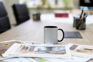 desenhos fotográficos impressos de projetos de interiores sobre a mesa e uma caneca de chá. foto